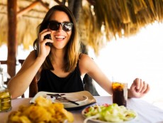 Dominican Republic, Woman by table, using phone