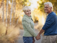 Portrait of happy senior couple holding hands while walking